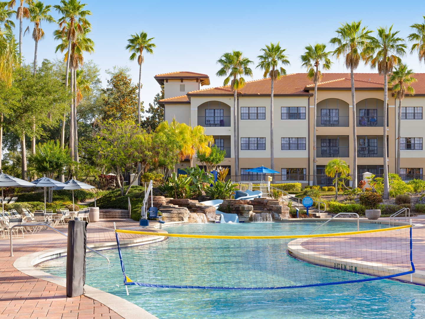 Pool surrounded by palm trees and sun chairs in North Village at Orange Lake Resort near Orlando, Florida.