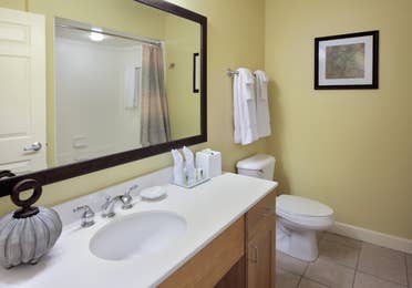 Bathroom with sink, large mirror, and toilet in a one-bedroom villa at Lake Geneva Resort