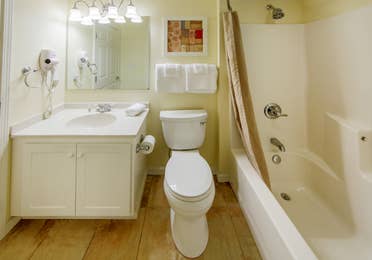 Bathroom with vanity, toilet, and tub in a villa at Oak n' Spruce Resort in South Lee, Massachusetts