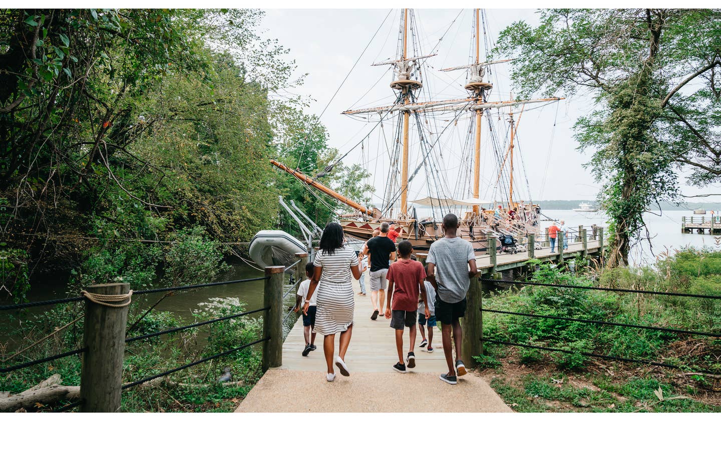 A family walks towards the Susan Constant ship at Jamestown Settlement in Williamsburg, Virginia.