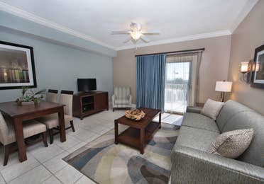 Living room with couch, flat screen TV, and access to balcony