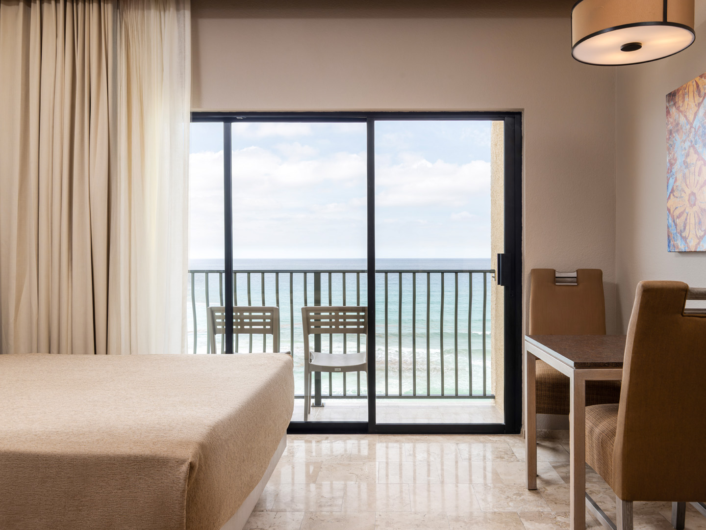 Oceanfront room with balcony seating and serene views.