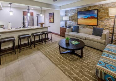 Living room with decorative stone wall and couch in a signature one-bedroom villa at Scottsdale Resort