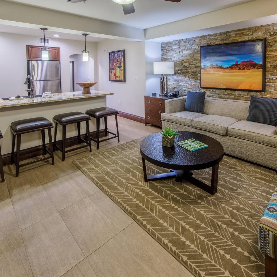 Living room with decorative stone wall and couch in a signature one-bedroom villa at Scottsdale Resort
