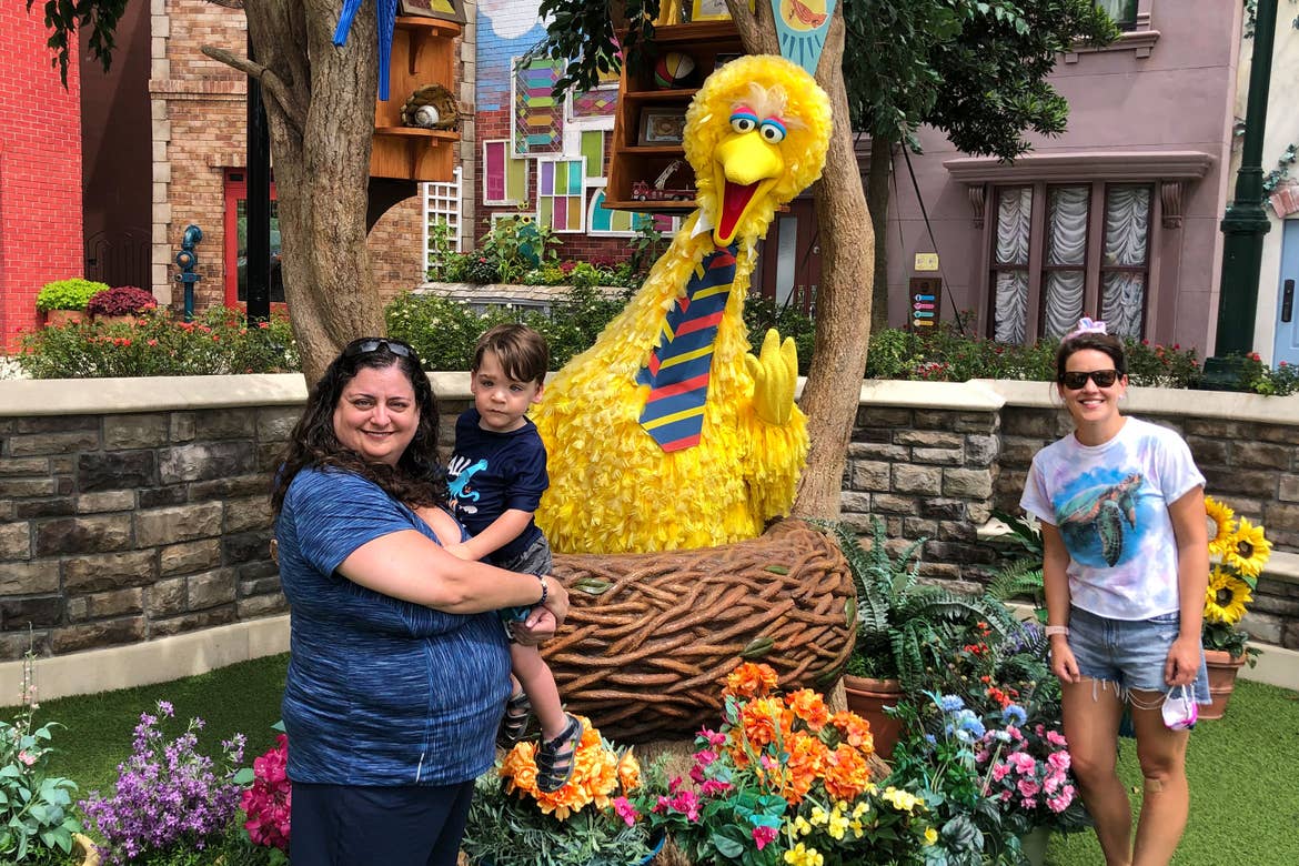 Theresa holds Dakota (left) with Jennifer (right) in front of Big Bird in his nest for a photo.