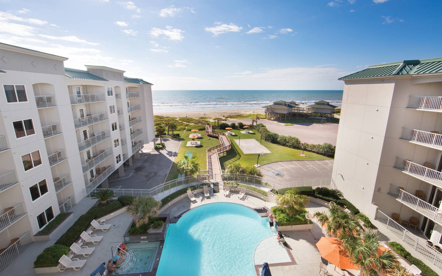 View of outdoor infinity pool and beach from Galveston Beach Resort room balcony in Texas.