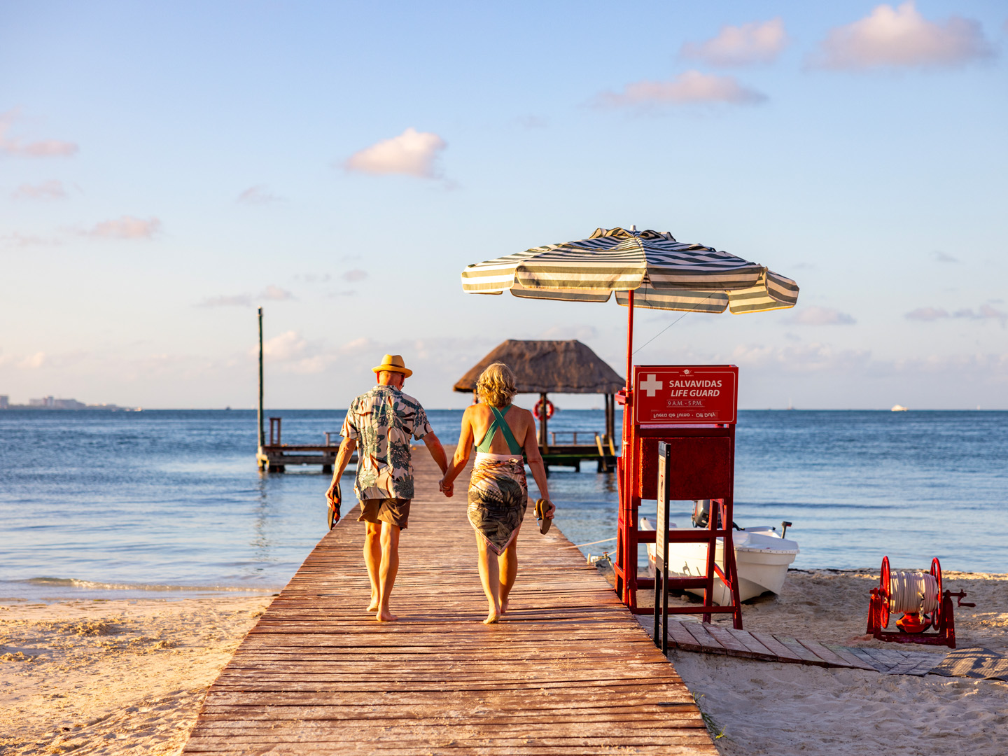 Couple walking on a pier at the beach.