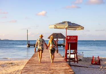 Couple walking on a pier at the beach.