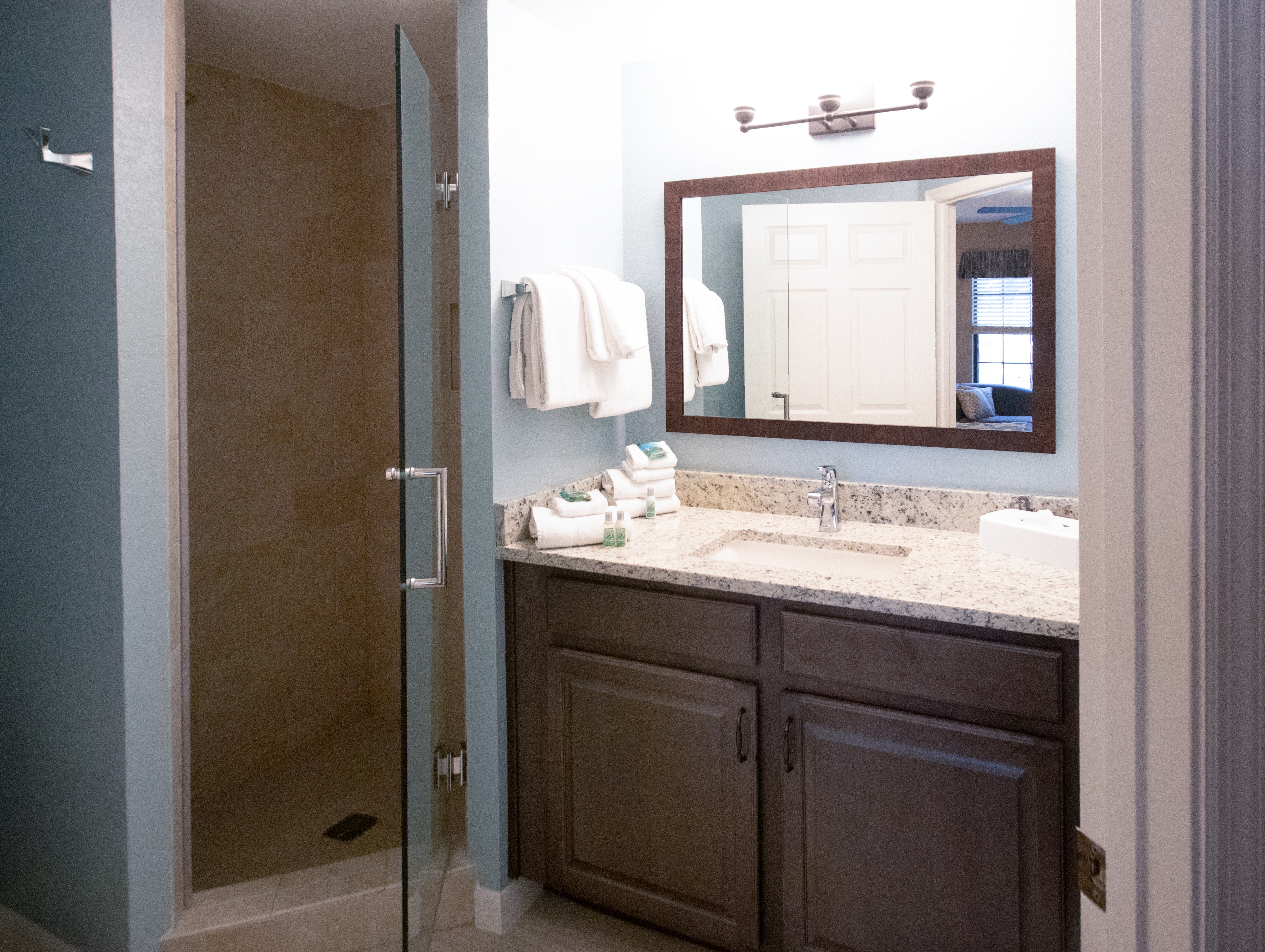 Bathroom with sink, large mirror, and walk-in shower in a villa in North Village at Orange Lake Resort near Orlando, Florida