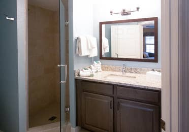 Bathroom with sink, large mirror, and walk-in shower in a villa in North Village at Orange Lake Resort near Orlando, Florida