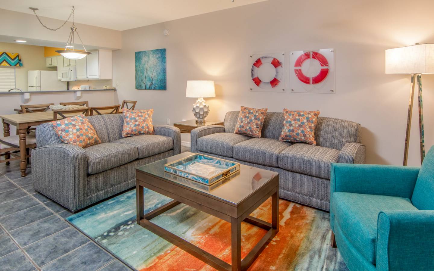 Living room with two couches, an accent chair, and coastal decor in a two-bedroom villa at Panama City Beach Resort