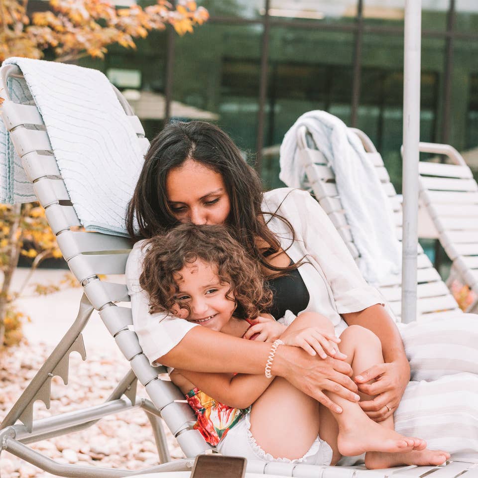 Mother snuggling child outside of pool at Williamsburg Resort.