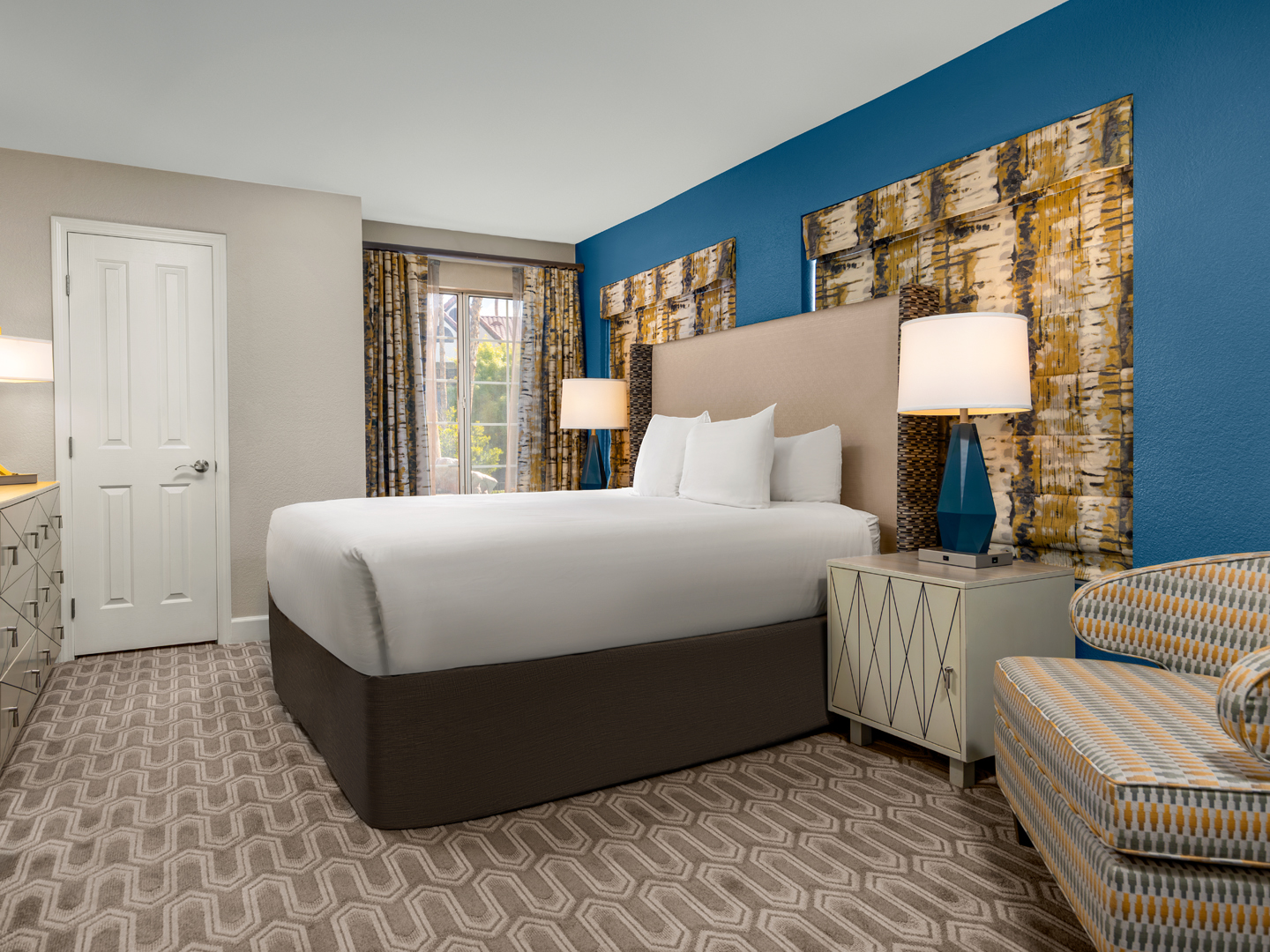 Bright, modern bedroom with bold hues and cozy seating.
