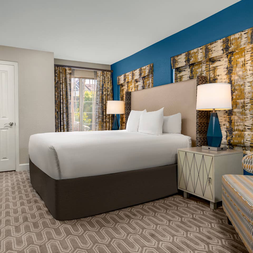 Bright, modern bedroom with bold hues and cozy seating.