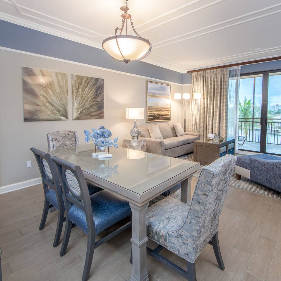 Dining room table with six chairs and coastal decor in a three-bedroom villa at Sunset Cove Resort in Marco Island, Florida