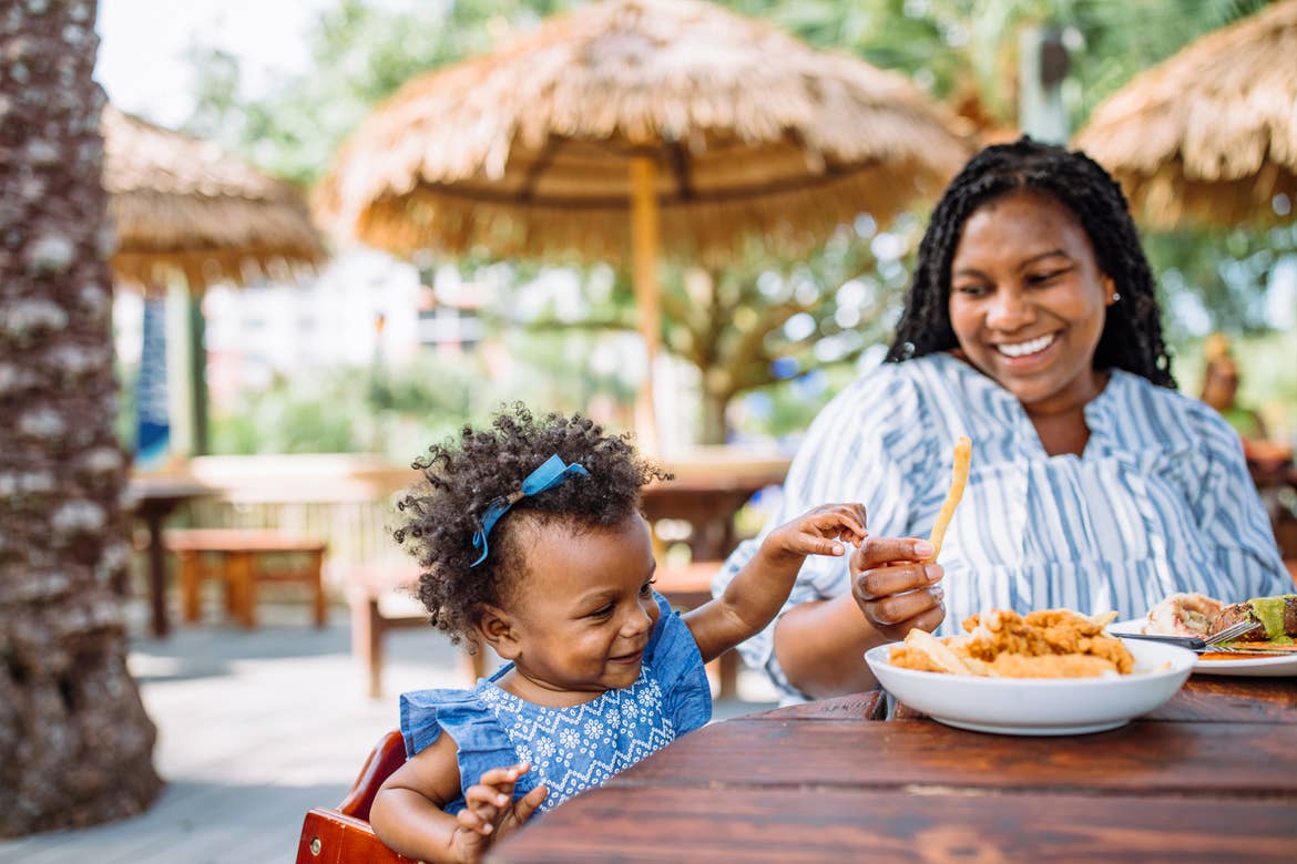 Krystin Godfrey (right) feeds her daughter, Creed (left) some fries at Tradewinds Bar & Grill in River Island at our Orange Lake Resort located in Orlando, FL.
