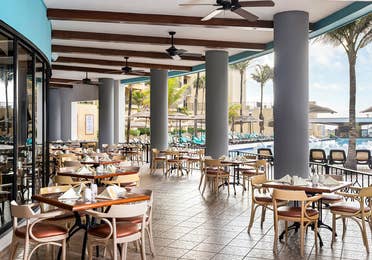 Poolside dining in a breezy, open-air setting.