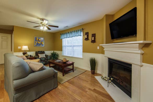 Living room with fireplace and TV in a three-bedroom ambassador villa at the Holiday Hills Resort in Branson Missouri.