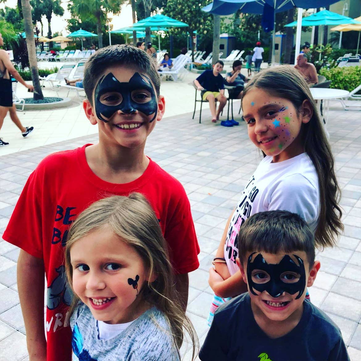 Featured Member, Sara Perezes family stands outside of our River Island pool wearing various face paintings.