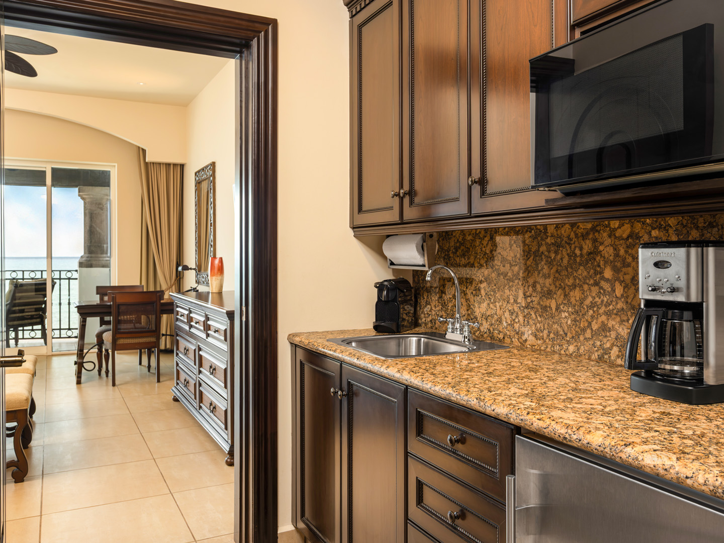 Kitchenette with dark wood cabinets and granite countertop.