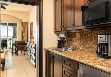 Kitchenette with dark wood cabinets and granite countertop.