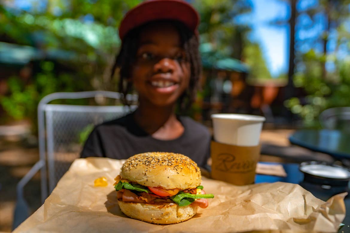 A breakfast sandwich and coffee and Karen’s son smiling in the background.