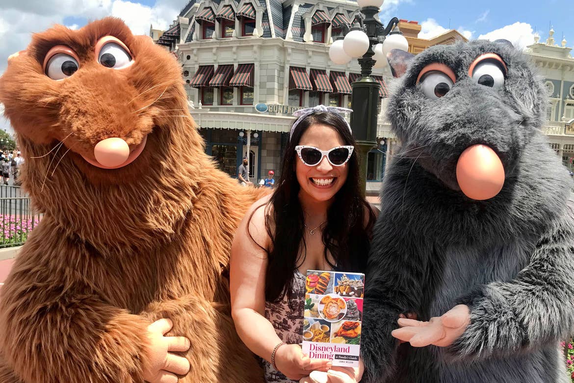 Jamie Nelson (middle) holds her authored book and stands next to Emile (left) and Remy (right) at Walt Disney World Resort.