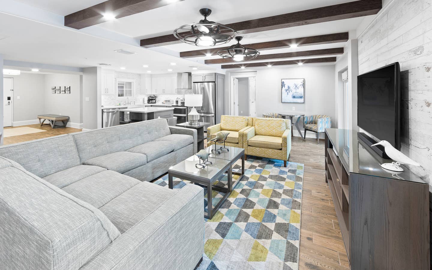 Living area with kitchen in background in a four-bedroom Signature Collection villa at Cape Canaveral Resort.