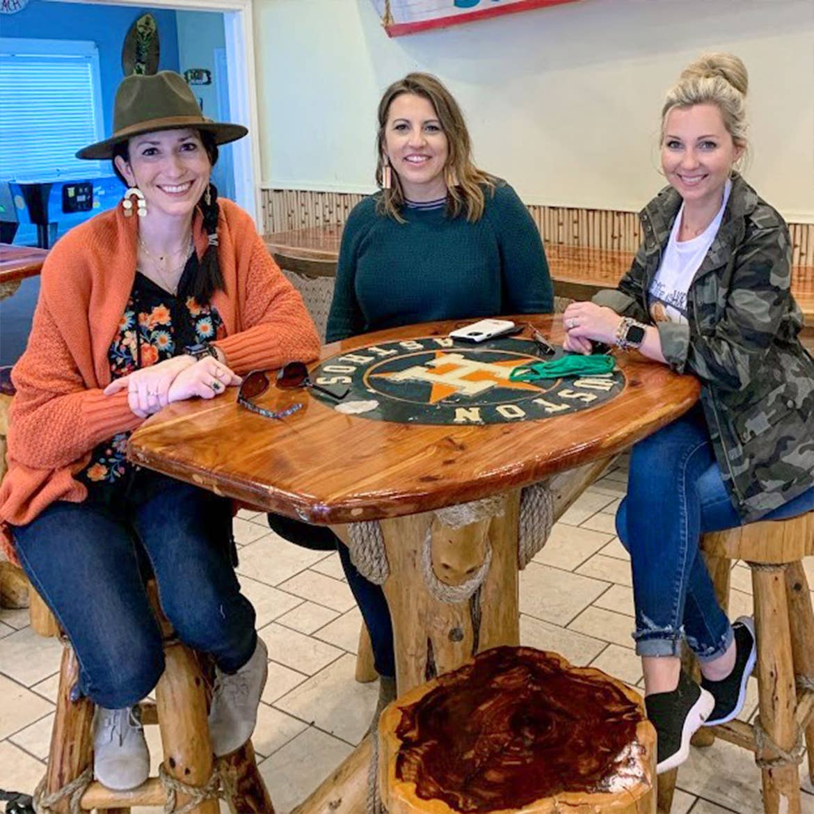 Featured Contributor, Amanda Nall (right) poses with her two friends at a table in Galveston, Tx.