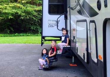 Angelica's children sitting on the steps of their RV.