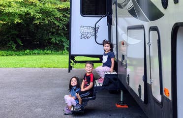 Angelica's children sitting on the steps of their RV.