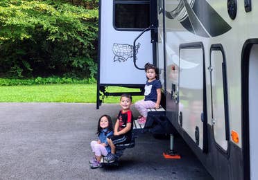 Angelica's children sitting on the steps of their RV.