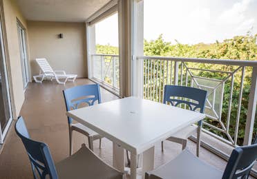 Balcony with outdoor table and chairs in a two-bedroom villa at Cape Canaveral Beach Resort.
