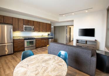 One bedroom villa living room with full kitchen, dining area, couch and TV at New Orleans Resort in Louisiana.