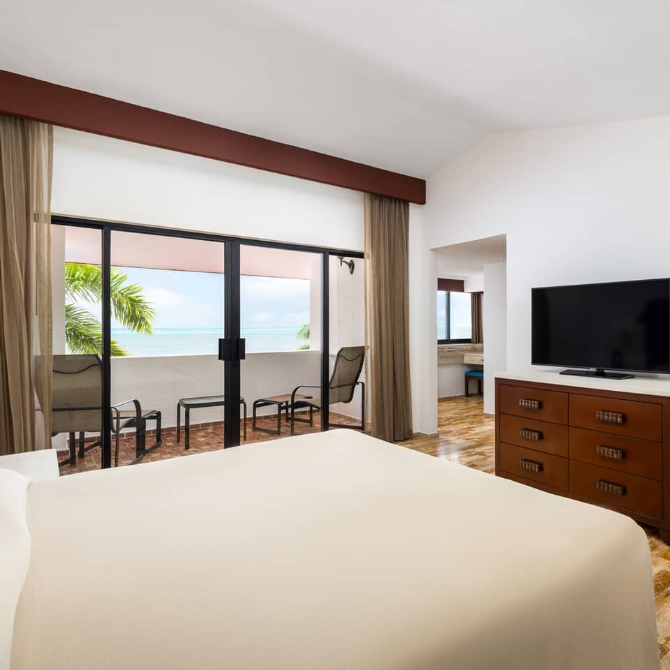 Oceanview villa bedroom with two beds and balcony access.