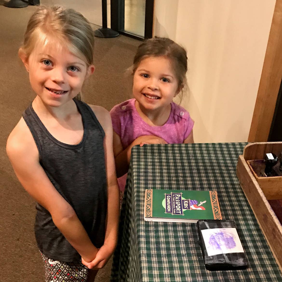 Author, Chris Johnstons' daughters, Kyndall (left), and Kyler (right) pose with their Passport stamp booklet.