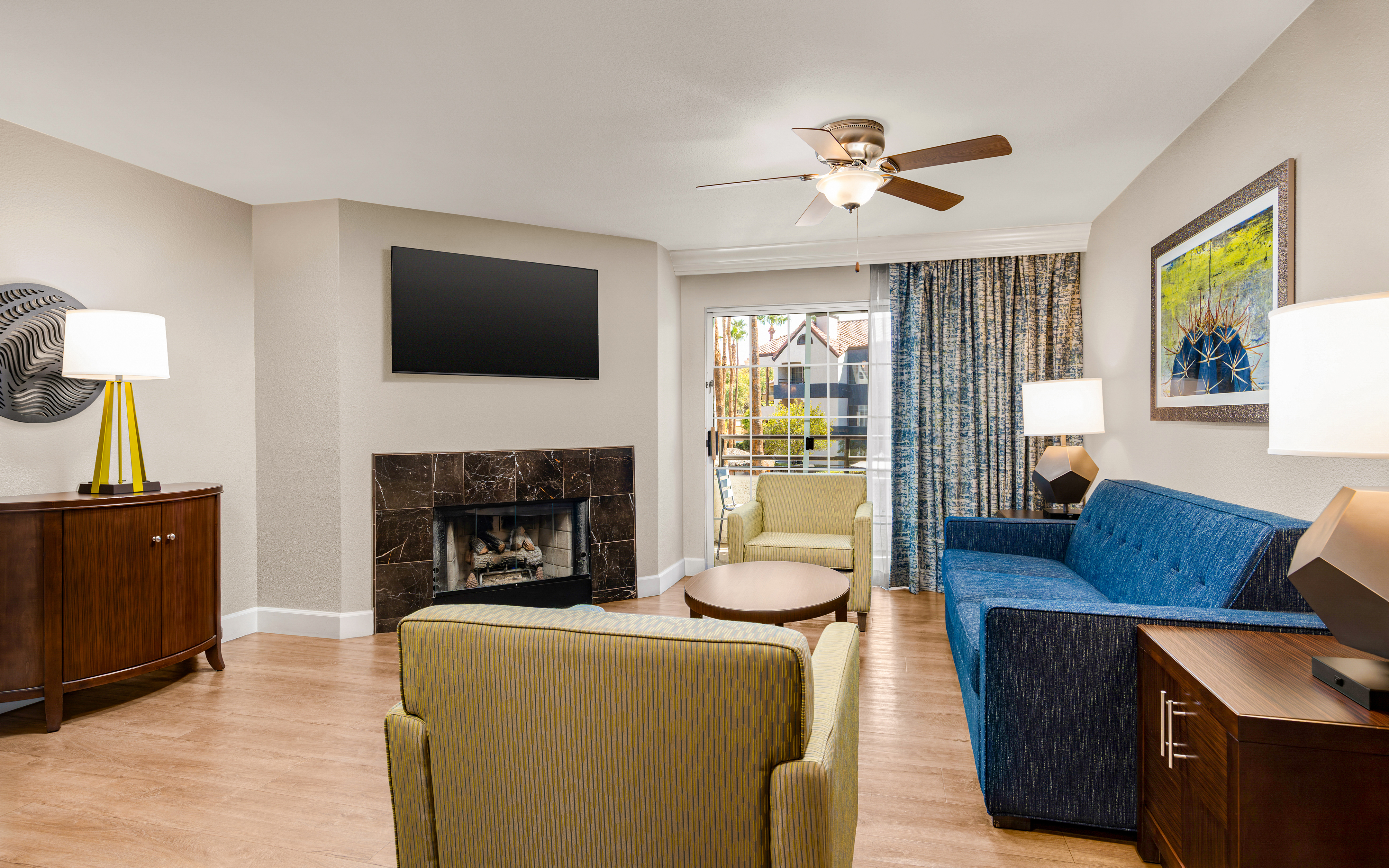 Bright living area with fireplace, balcony access, and modern decor.
