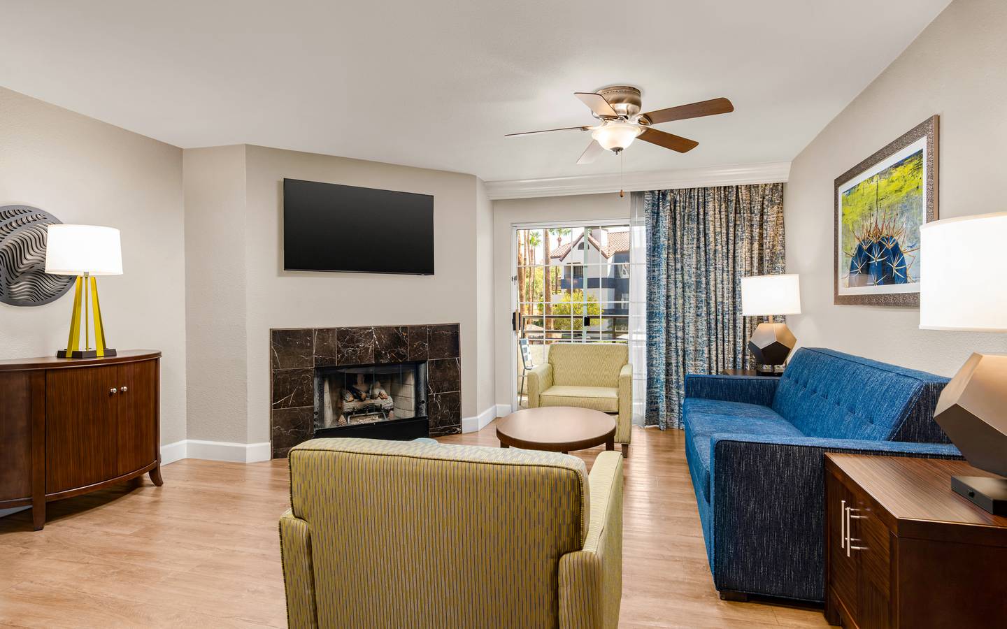 Bright living area with fireplace, balcony access, and modern decor.