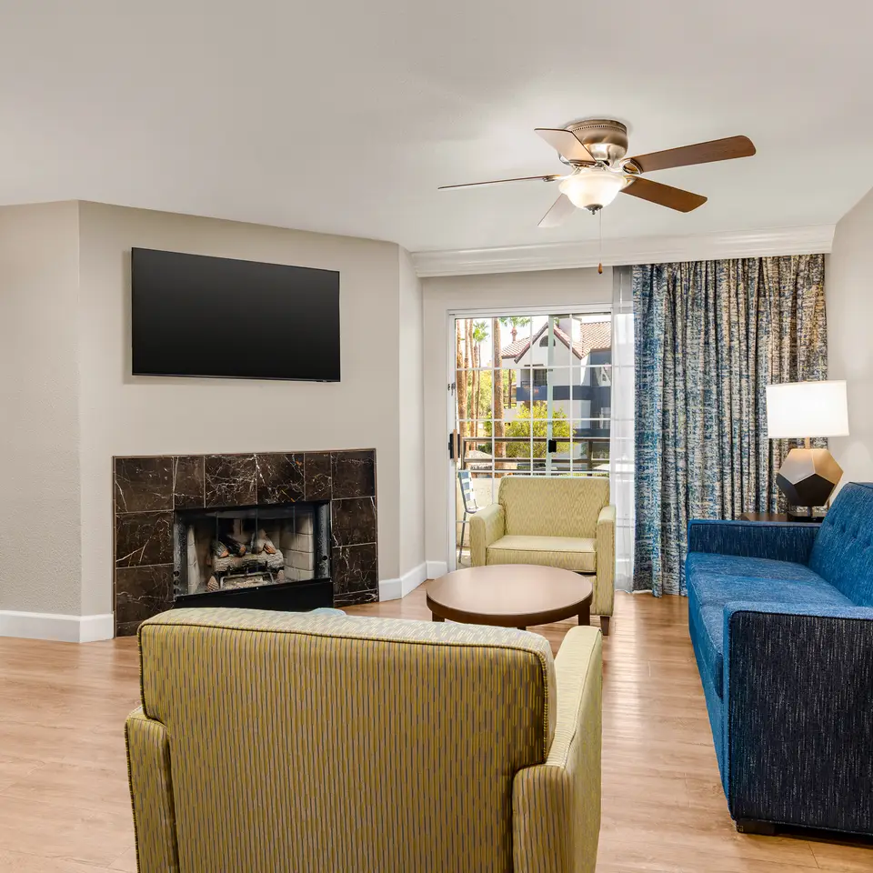 Bright living area with fireplace, balcony access, and modern decor.