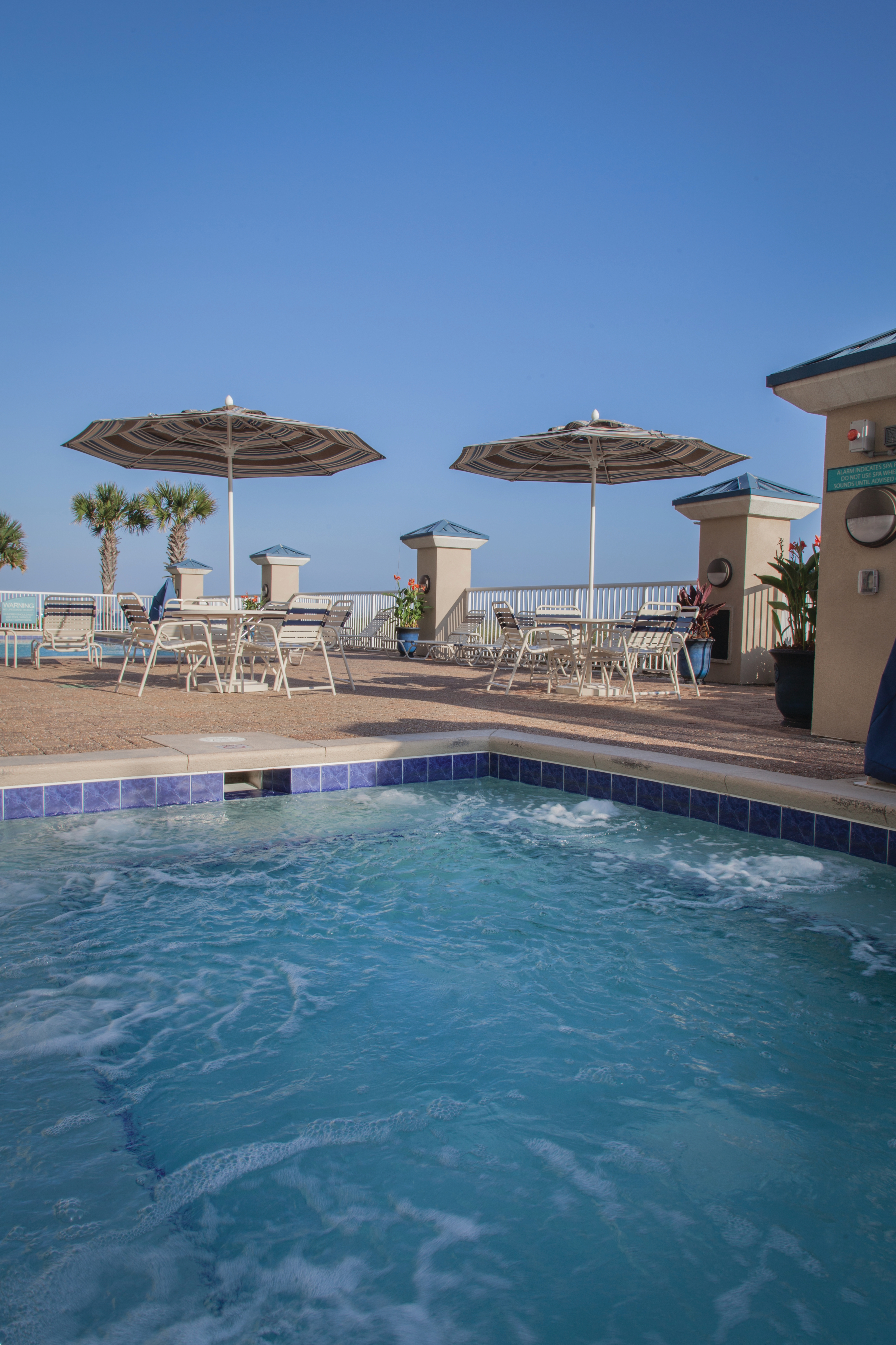 Outdoor pool near tables and chairs at Panama City Beach Resort.