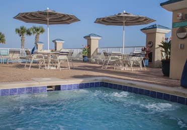 Outdoor pool near tables and chairs at Panama City Beach Resort.