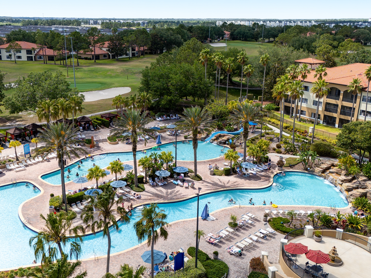 Pool with sun chairs surrounded by palm trees in the North Village at Orange Lake Resort near Orlando, Florida.