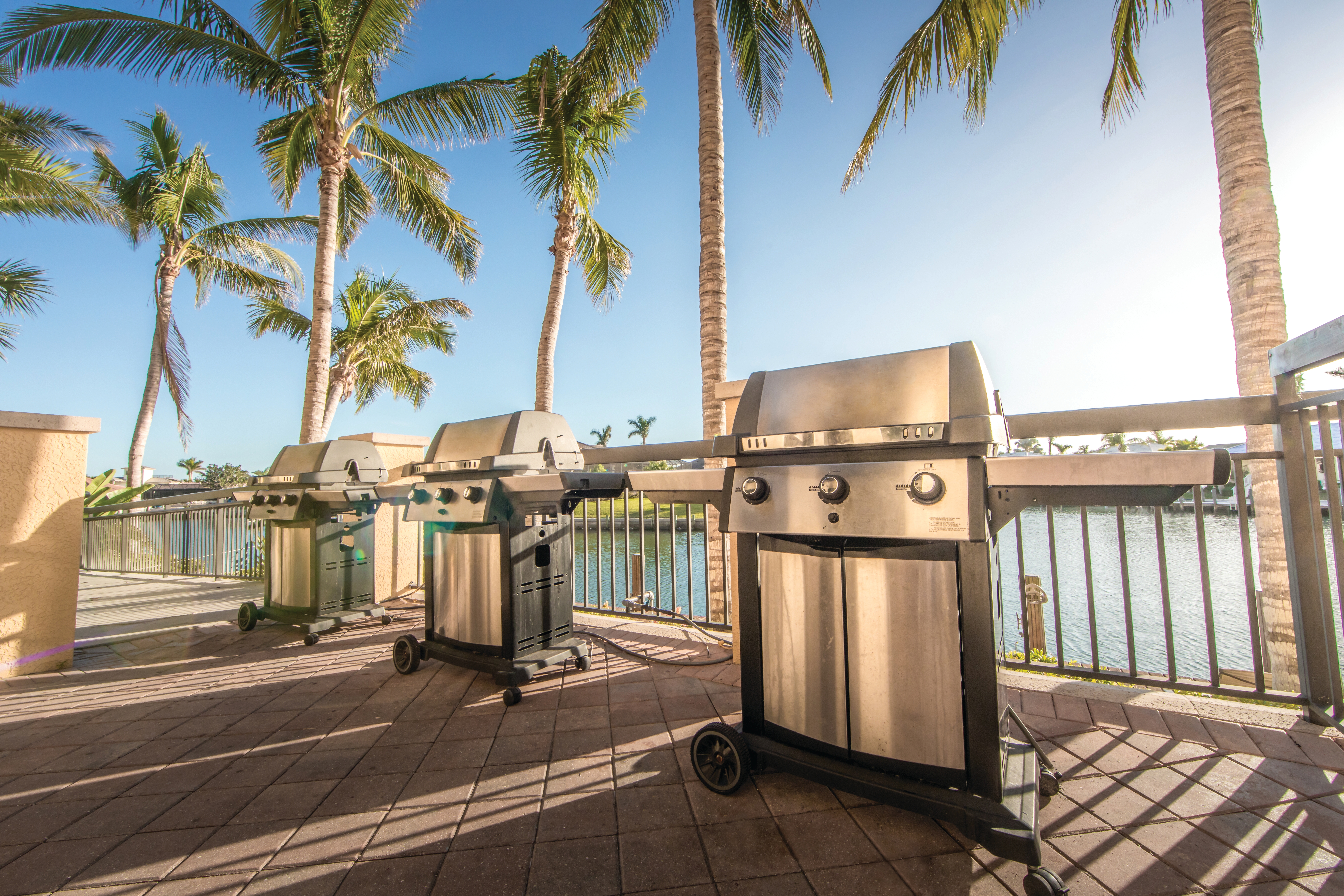 Outdoor grilling area with three stainless steel grills at Sunset Cove Resort in Marco Island, Florida.