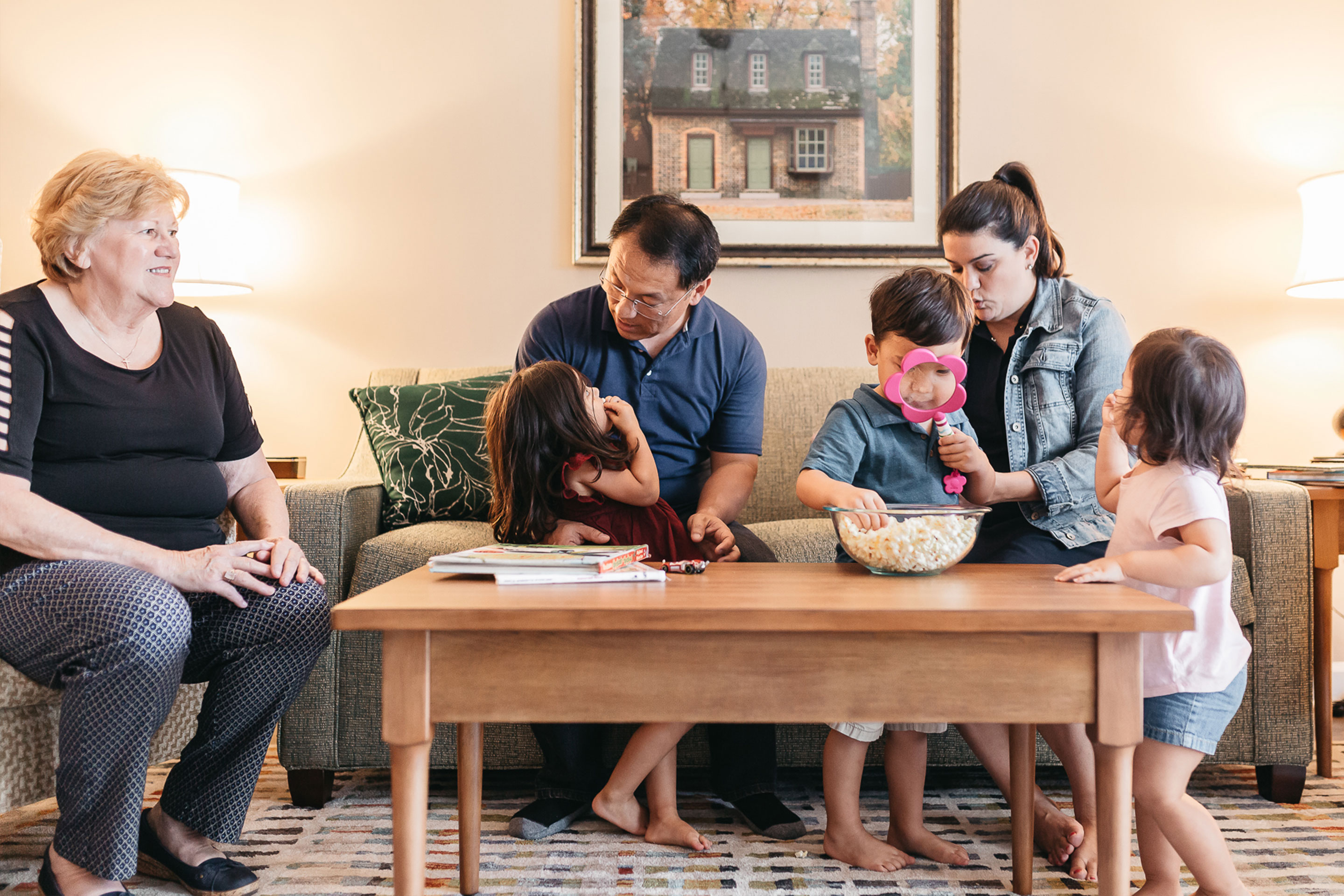 (Left to right) Angelica's mom, Angelica's husband, featured Contributor, Angelica Kajiwara, and her three children sit in the living room of a villa of our Williamsburg resort in Williamsburg, Virginia.