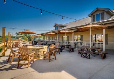 Outdoor tables with chairs and fire pits at Piney Shores Resort in Conroe, Texas.