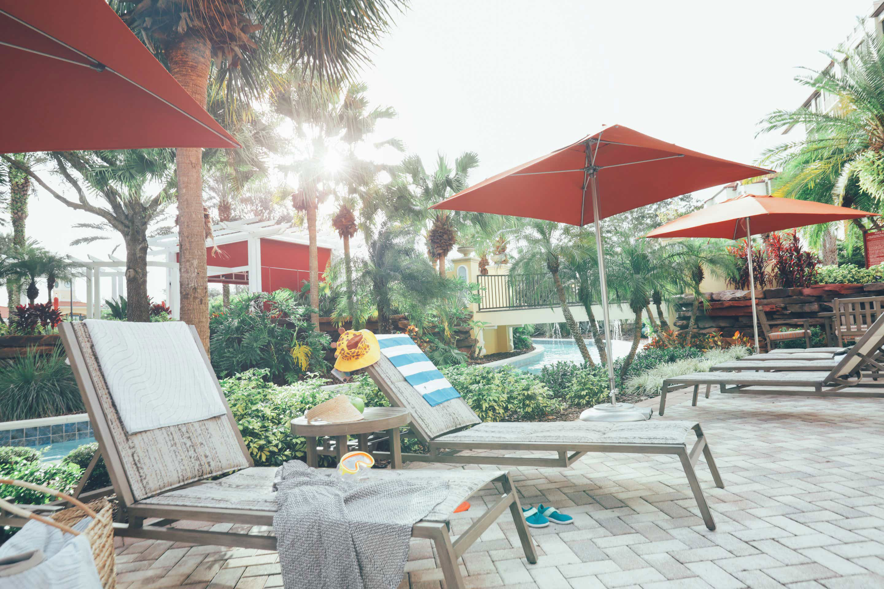 Beach chairs with swimming toys and towels placed next to our lazy river at Orange Lake Resort in Florida.
