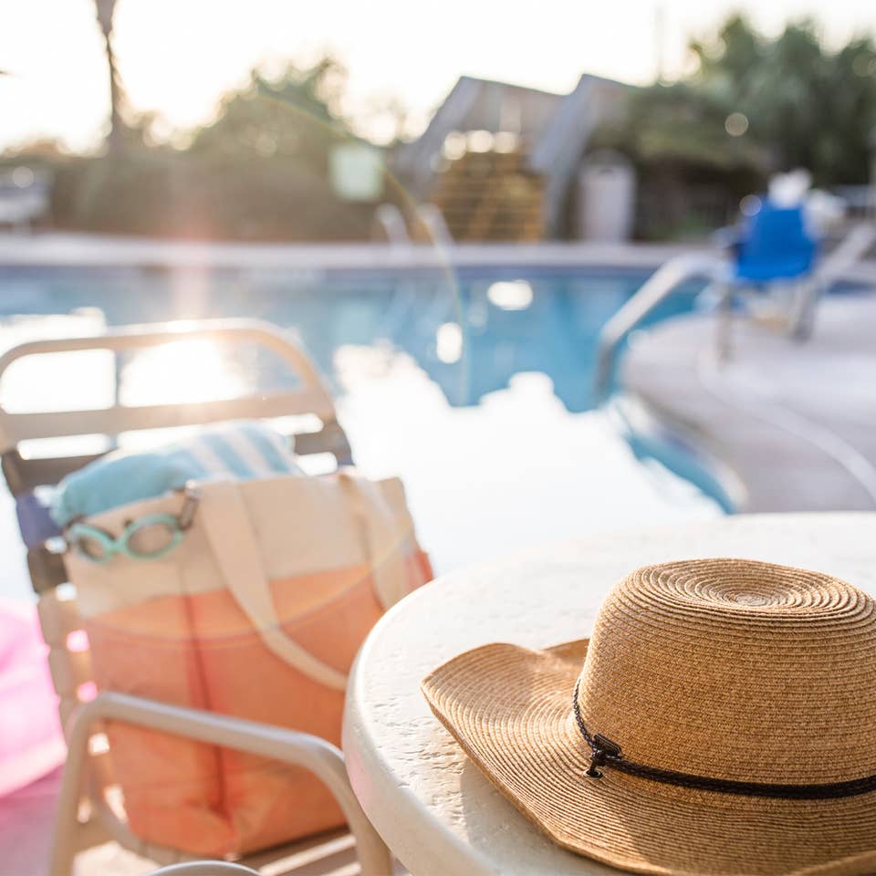 Jennifer's hat sits on a table with swimwear next to the poolside of a Holiday Inn Club Vacation Resort.