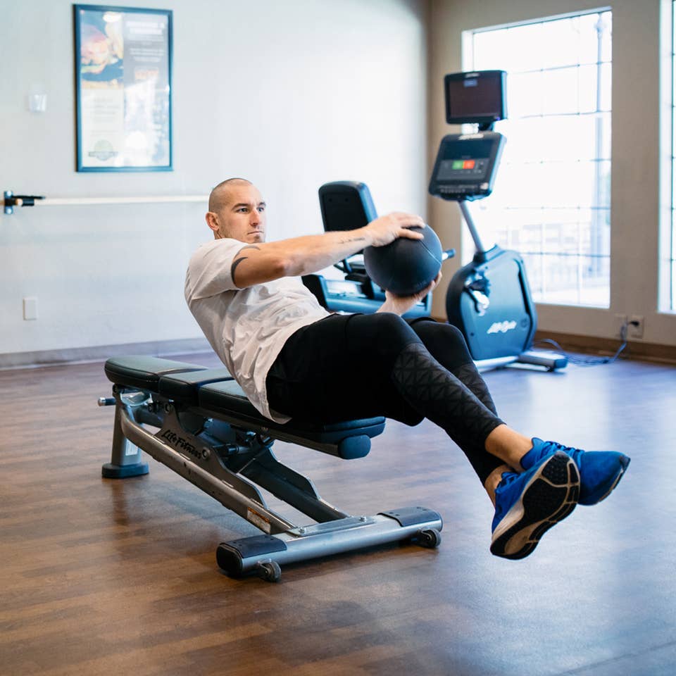 Man working out with weight ball in fitness center at Desert Club Resort in Las Vegas, Nevada.
