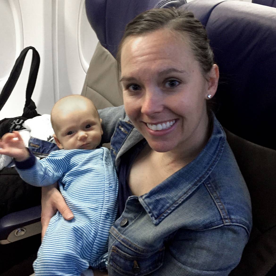 Author, Sarah Conroy, holds her son, Logan, as an infant near the window seat of the aircraft.