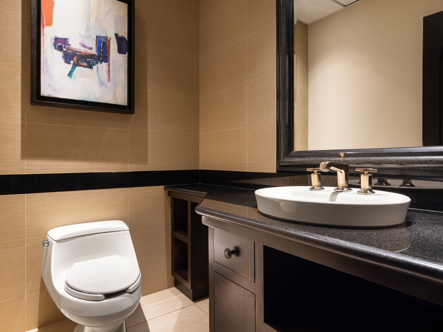 Contemporary half bath with an ample sink, vanity, and art.